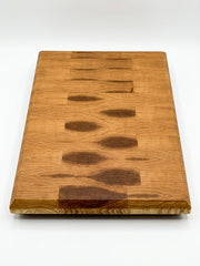 End grain hickory cutting board showing the wood's natural light and dark grain variations, photographed on a clean white background
