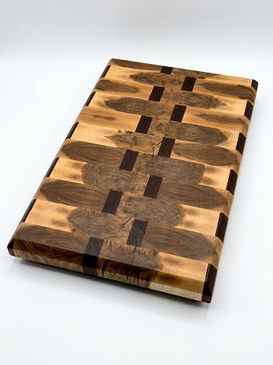 End Grain wooden cutting board with a geometric pattern of Maple and African Sapele showing the light and dark wood grains, photographed on a clean white background.